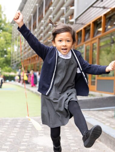 Find Your Place to Grow: A Guide to the Early Years at The British School in the Netherlands. Girl jumping in the yard.