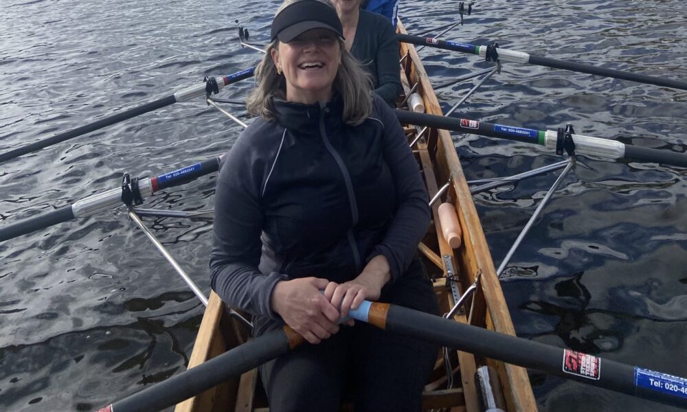 ACCESS Stories Logo January 2026. My Journey to Belonging in Amsterdam. Photo of Erin Frobenius in a rowing boat.