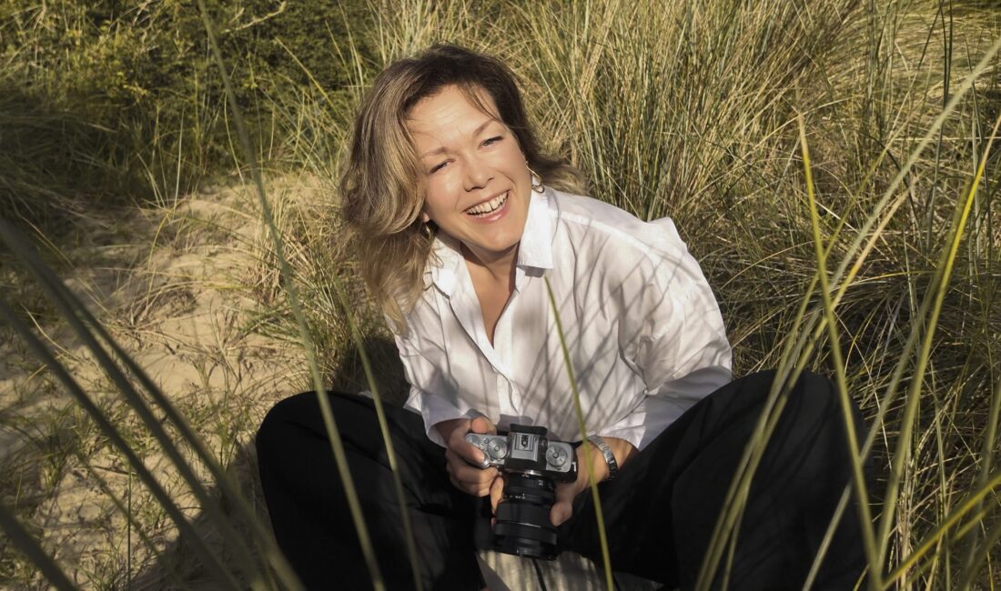 ACCESS Stories July 2026. How the Netherlands Became My Home. Nataliya Volosovych smiling holding her camera.