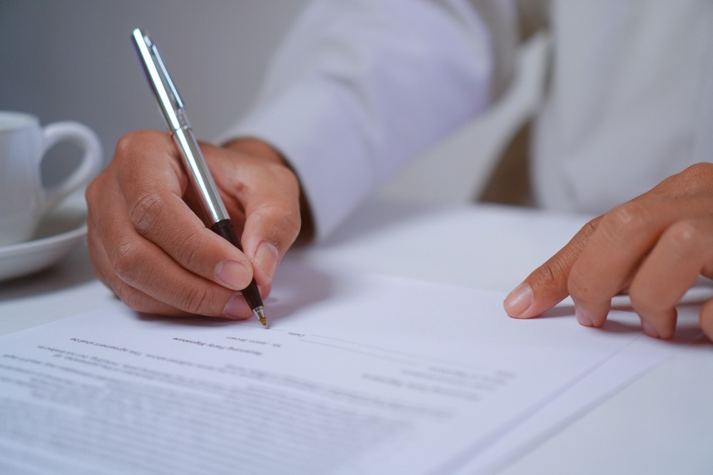 A guide through your new employment agreement in the Netherlands. Man signing employment agreement.